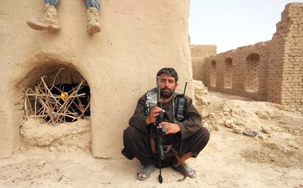 A member of the Afghan security forces takes a break during a military operation to seize Babur, a Taliban-controlled village in Kandahar province's Arghandab valley. - PHOTO BY DION NISSENBAUM/MCT