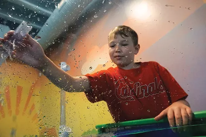 Connor Westlake is engineering a water blaster to rain over Lee, the photographer who is inside the viewing bubble. The Bubble Viewer is part of the Healthy Earth Water table that teaches kids about how water sustains human life and how we need to be good - PHOTO BY LEE MILNER
