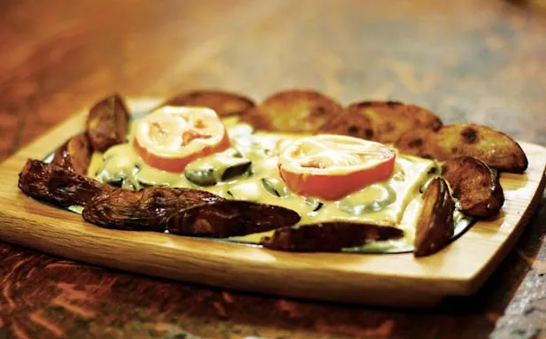 This is a classic horseshoe, albeit one that substitutes sautéed mushrooms and tomato for the original ham. - PHOTO BY PATRICK YEAGLE