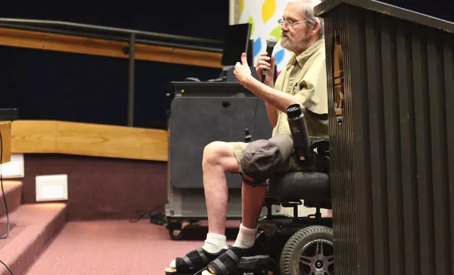 Speaking from his wheelchair, Dennis Garland of Chatham addresses regulators in a May 21 public hearing on medical marijuana, urging the state to roll the program out immediately. - PHOTO BY PATRICK YEAGLE