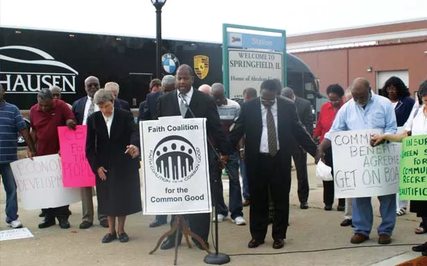 Pastor T. Ray McJunkins leads prayer after calling on local and state officials to sign Springfield agreement. - PHOTO BY HOLLY DILLEMUTH