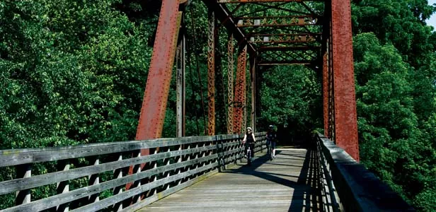 Two cyclists cross a former railroad bridge-turned-bikepath on the Lost Bridge Trail. - PHOTO BY PATRICK YEAGLE