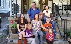 Ryan and Dawn Mobley with their five children – Hannah, left, Rachel, Ellie, top, Aiden and Lydia, front. The Mobleys bought their Sixth Street home from Enos Park Development a year ago and have been restoring it since, using some contractors and - PHOTO BY JOE COPLEY