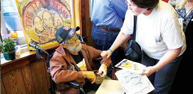 Bob signing his artwork and saying goodbye to people at his last art show at the Cozy Dog. - PHOTO BY B. DAVE HINE