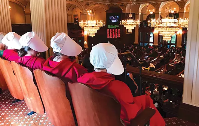 Women dressed as Handmaids, characters from Margaret Atwood’s dystopian novel, The Handmaid’s Tale, watch as Rep. Kelly Cassidy, D-Chicago, presents her arguments in favor of the Reproductive Health Act on the floor of the House on Tuesday, - PHOTO CAPITOL NEWS ILLINOIS PHOTO BY REBECCA ANZEL