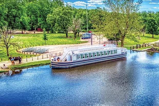 A replica of an 1800s boat sits on the Illinois and Michigan Canal at LaSalle, Illinois, ready to take visitors on a slow ride on the canal. The canal once carried cargo and passengers between the Illinois River and Chicago. - PHOTO BY RANDY VON LISKI