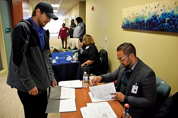 Christopher Kraus watches as his petitions are file stamped by a Sangamon County Circuit Clerk volunteer. - PHOTO BY DAVID BLANCHETTE