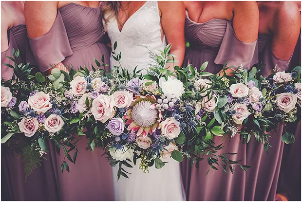 Bride Lauren Brown chose a Bohemian-style clutch made up of a king protea with thistle, brunia, peonies and roses. - PHOTO BY KARA EVANS PHOTOGRAPHY