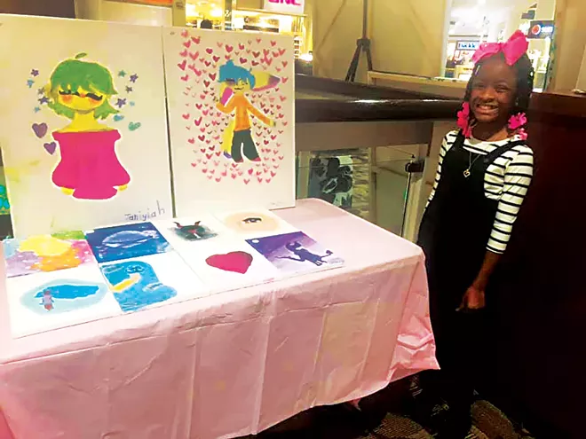Nine-year-old Janiyiah Green shows off her work at one of The Rainbow Room’s art sales. - PHOTO COURTESY THE RAINBOW ROOM