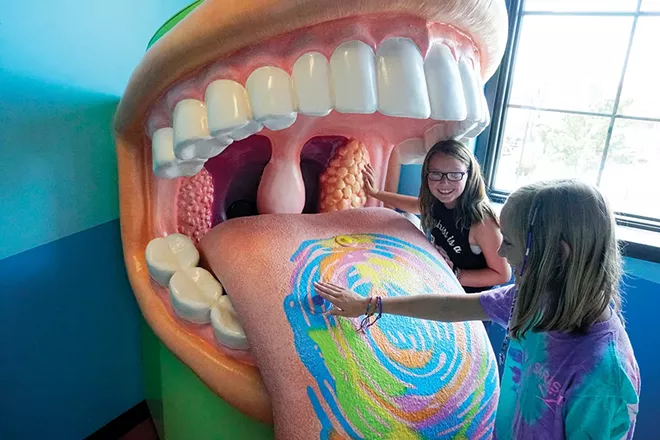 Bella Hose and Myla Shannon are at the Big Mouth exhibit to learn about taste buds, infections of the tonsils, the teeth and all the doctors that keep the mouth healthy. - PHOTO BY LEE MILNER