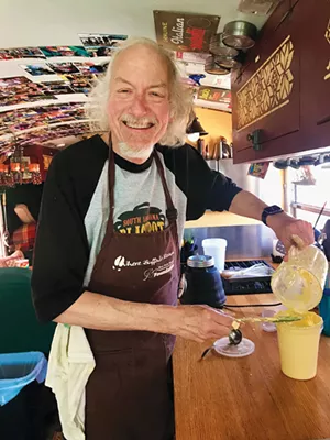 Peter Glatz mixes up some aioli in the school bus he renovated several years ago. - PHOTO BY ANN SHAFFER GLATZ