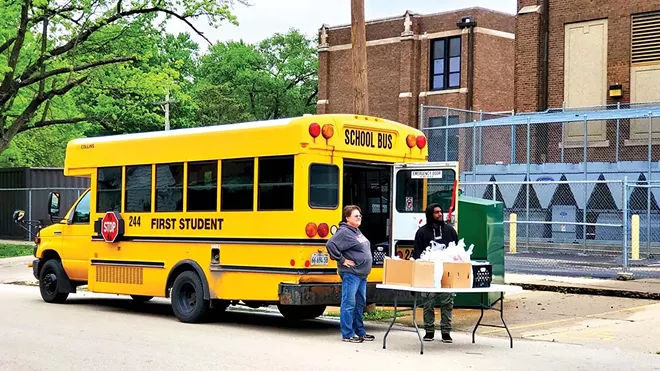 Families picked up free meals from various schools and satellite bus locations, this one outside of Feitshans Elementary School on South 15th Street. - PHOTO BY RACHEL OTWELL