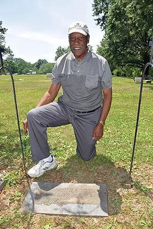 Allan Woodson at the grave marker of his mother, Charlotte Woodson. The Woodson family is not interred in the Colored Section of Oak Ridge Cemetery, but family members chose to be buried near other black families that they knew in Springfield. - PHOTO BY DAVID BLANCHETTE