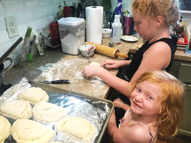 Elizabeth Meyer helps her big sister, Maddie, make savory sweet corn and ham turnovers. - PHOTO BY ASHLEY MEYER