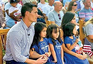 Jesse Sullivan and daughters Charley, Lincoln and Scout with wife Monique listen as a speaker introduces the candidate. - PHOTO BY SCOTT REEDER