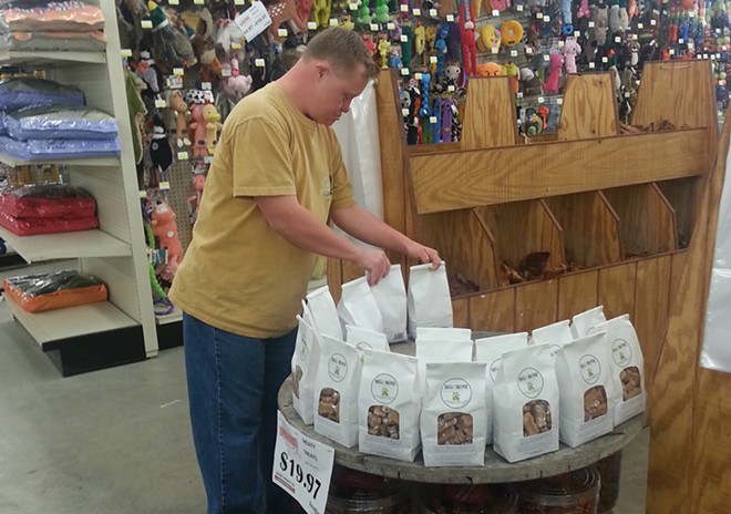 Michael, a Sparc employee, stocks a display of Beg-O-Bone dog biscuits at a Springfield retailer. - PHOTO COURTESY SPARC