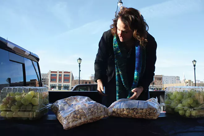 Leslie Sgro regularly fills certain micropantries, including the one at Fifth and Jackson streets. She stopped by Dec. 13 to drop off some fresh produce and canned goods. - PHOTO BY STACIE LEWIS.