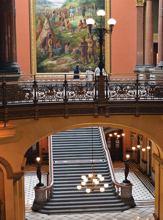 Grand Staircase, as seen from across the rotunda. Simple chandeliers by Mitchell, Vance & Co. of the 1870s were replaced in the 1880s by fixtures from W.C. Vosburgh. Present chandeliers are reproductions by the St. Louis Antique Lighting Co., installed 2013.
