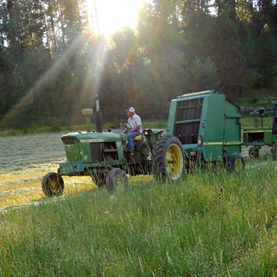 My husband, Doug Harris (73) shutting off the tractor and baler at sunset. 6//28/2015 taken at Cedar Ridge east of Kendrick, Idaho. Sharon Harris, photographer