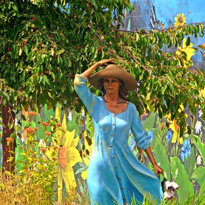 This image of a sculpture of a lady in a blue dress surrounding by flowers was taken in the center of Joseph, Oregon, by Leif Hoffmann (Clarkston, WA), when visiting the town in the afternoon of August 27, 2022. The main street of Joseph, Oregon, is home to many larger-than-life-size bronze sculptures.