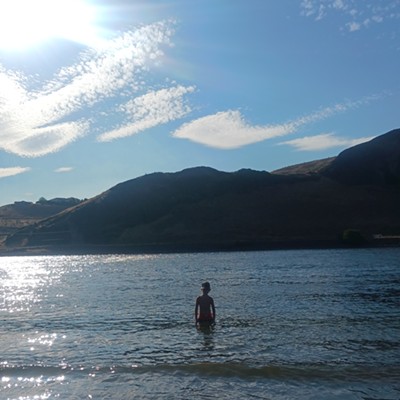 My nephew standing in The Snake River at Dusk.