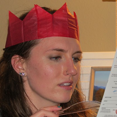 Lauren Paterson of Kamiah examines the lottery ticket that Santa stuffed in her stocking.   
    
    Lauren is wearing a paper crown snagged from a traditional "Christmas cracker." It's quite common for British people to wear a paper crown on Christmas Day. The idea of wearing paper crowns probably derives from the Twelfth Night celebrations, where kings or queens supervised the proceedings. Lauren's mother-in-law, Le Ann Wilson of Orofino, took the photo Dec. 25.