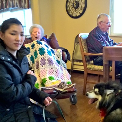 Darrell Kent playing piano for residents at the Aspen Park Health Center in Moscow with his granddaughter, Jillian, and dog, Koto.