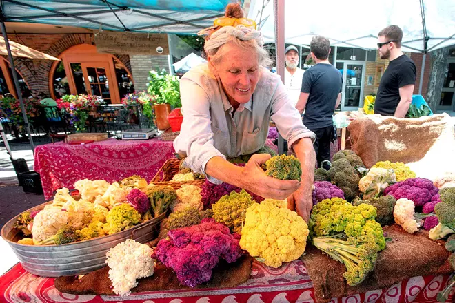 A woman organizes colorful cauliflower at her stand at a past Moscow Farmers Market. It returns Saturday for customer foot traffic, with strict distancing rules. Pete Caster/Lewiston Tribune - PETE CASTER/TRIBUNE FILE PHOTO