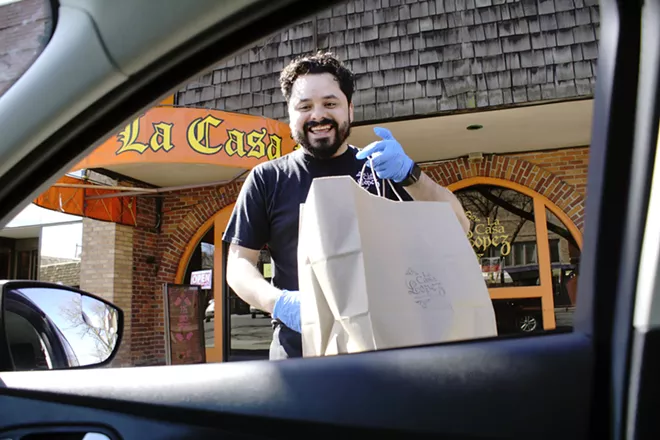 Mitch Lopez brings an order to a La Casa Lopez customer in a car Saturday afternoon in Moscow after fears over the spread of coronavirus shut down in house dining. - KAI EISELEIN/DAILY NEWS