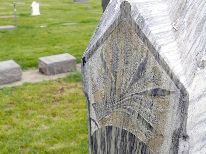 A sheaf of wheat is engraved on a headstone in the Colfax Cemetery. Tara Roberts/for Inland 360 - TARA ROBERTS/INLAND 360