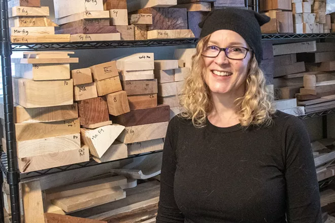 Former scientist turned artist Kristin LeVier, of Moscow, poses for a picture in front of a storage of her artwork materials consisting of mostly wood and cardboard. “Cardboard boxes are like gold to woodworkers,” said LeVier. - ZACH WILKINSON
