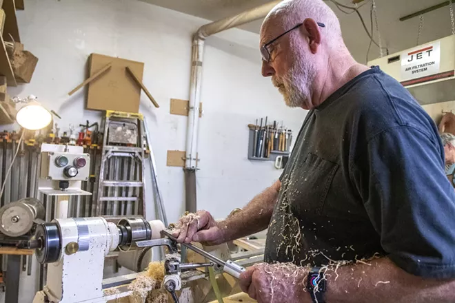 Covered in saw dust, Jim Christiansen makes a wooden bowl using a gouge while turning it on a lathe at the Palouse Woodworkers Collaborative in Moscow. - ZACH WILKINSON/360