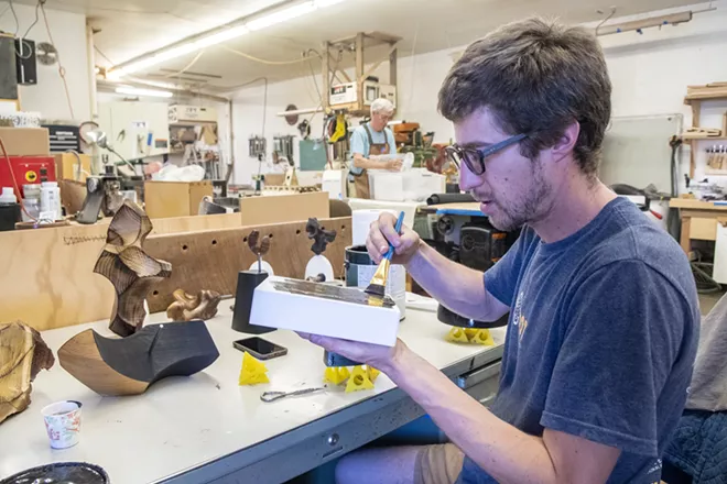 Ben Carpenter applies a coat of paint to a piece he calls “Ax Oxe.” The project involves multiple layers, and Carpenter drilled holes into individual pieces so that they can fit into one another upon presentation. - ZACH WILKINSON/360