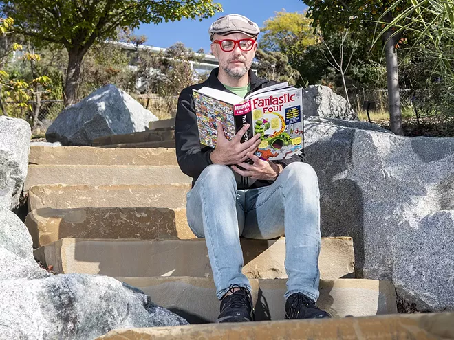Roger Whitson, an associate professor of English at Washington State University, holds a Fantastic Four volume one omnibus while posing for a portrait on a set of steps at the University of Idaho Arboretum and Botanical Garden on Friday afternoon, Oct. 1, 2021. “I’ve always read comics, it’s like a comfort food to me,” said Whitson. - ZACH WILKINSON/INLAND 360