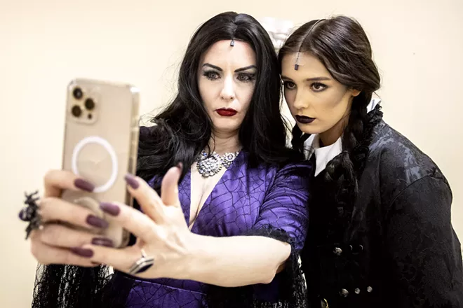 Amy Stout, playing Morticia Addams, takes a photo with Sydnee Swift, 17, playing Wednesday Addams, with their best Addams Family faces before a rehearsal for the Addams Family at the old Lewiston High School on Monday evening. - AUGUST FRANK/360