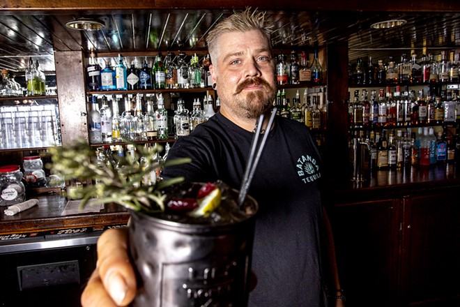 Kris Maxey, owner and bartender at Brock's, holds out the bar's Holiday Mule, a popular season drink at the bar. - AUGUST FRANK/360