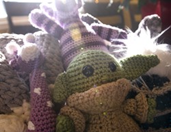 Baby Grogu headlines a collection of creations crocheted by PJ Mosman, displayed here in the Mosman family dining room. - CAITLIN BEESLEY/TRIBUNE