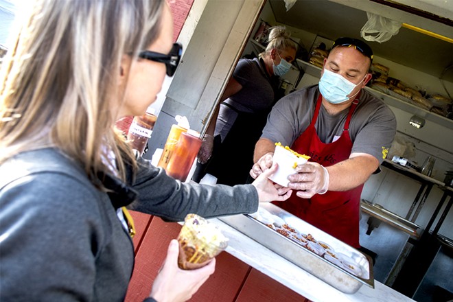 Justin Lewis hands Megan Larson her order of a cup of mac and cheese to go along with a parfait at Rosie’s Ribs during a Lewiston Food Truck Night at the Nez Perce County Fairgrounds. - AUGUST FRANK/INLAND 360 FILE