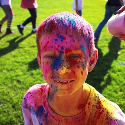 A young student from Parkway Elementary takes a quick break from his school color run for a picture.