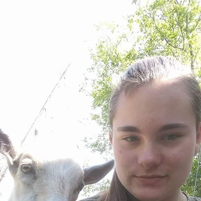 Emily Adams being photo bombed by her goat Hatfield