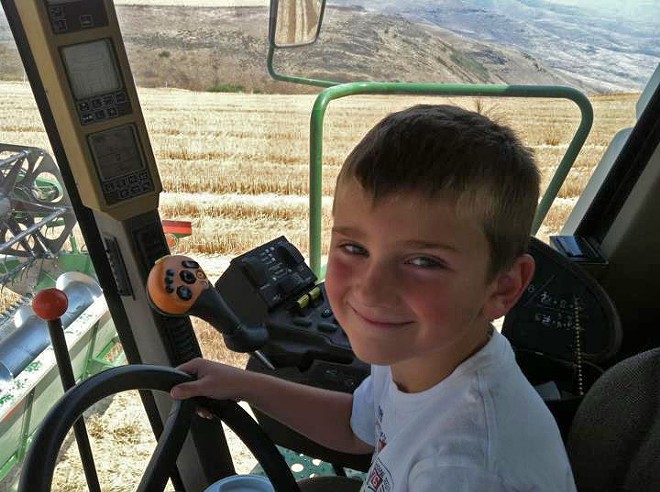 Seth Vestal, 6, gives his uncle a hand operating combine. Seth is the son of Molly and Rick Vestal of Genesee and was driving with his uncle, Chris Moser, during harvest on the Genesee Rim.