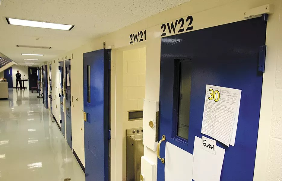 A corrections officer stands at the end of the "suicide watch" cell corridor at the Spokane County Jail. - JACOB JONES