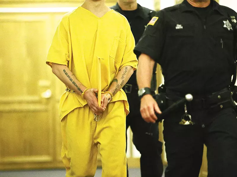 A handcuffed man is escorted in the halls of the Spokane County Superior Court. - YOUNG KWAK