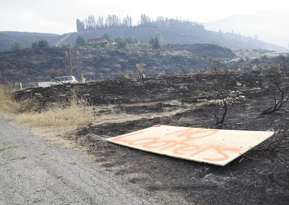 A plywood sign reads “No looters” along Highway 153 in the Methow Valley, where many homes were destroyed by the Carlton Complex Fire. - JACOB JONES