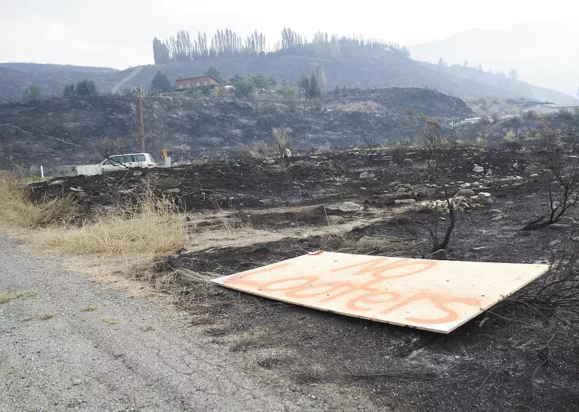 A plywood sign reads “No looters” along Highway 153 in the Methow Valley, where many homes were destroyed by the Carlton Complex Fire. - JACOB JONES