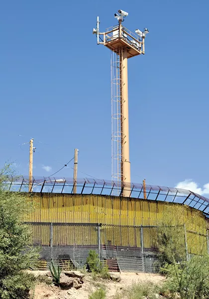 A surveillance tower seen from the Mexican side of a wall on the border. - JONATHAN MCINTOSH