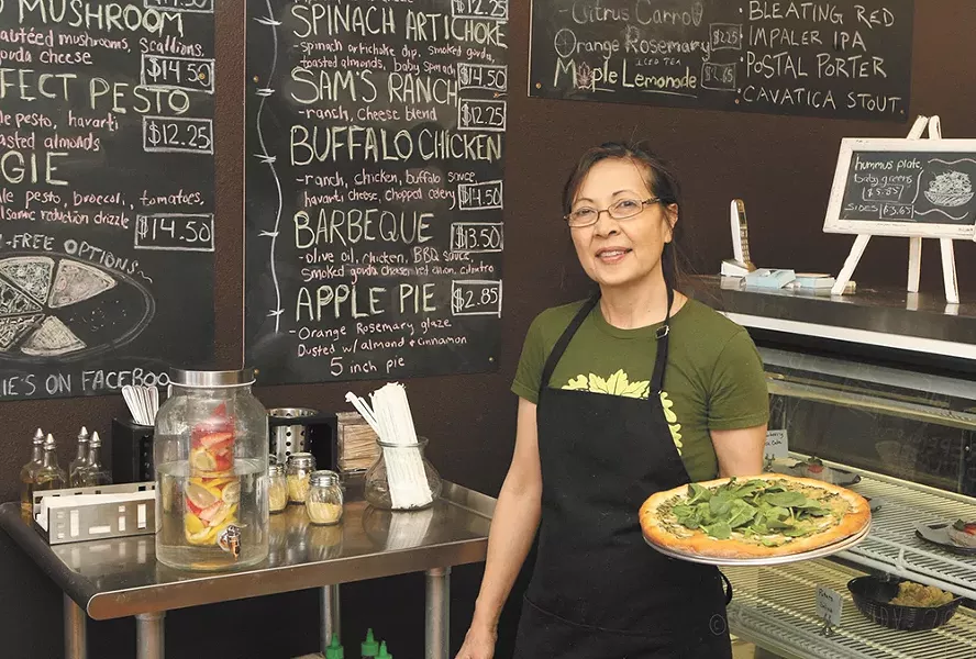 Allie's Vegan Pizzeria owner Atania Gilmore with her spinach artichoke pizza. - MEGHAN KIRK