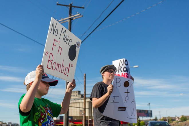 Andon Webster, left, and older brother Russell Webster, right, protest against the threat of bombing Iraq. - MATT WEIGAND