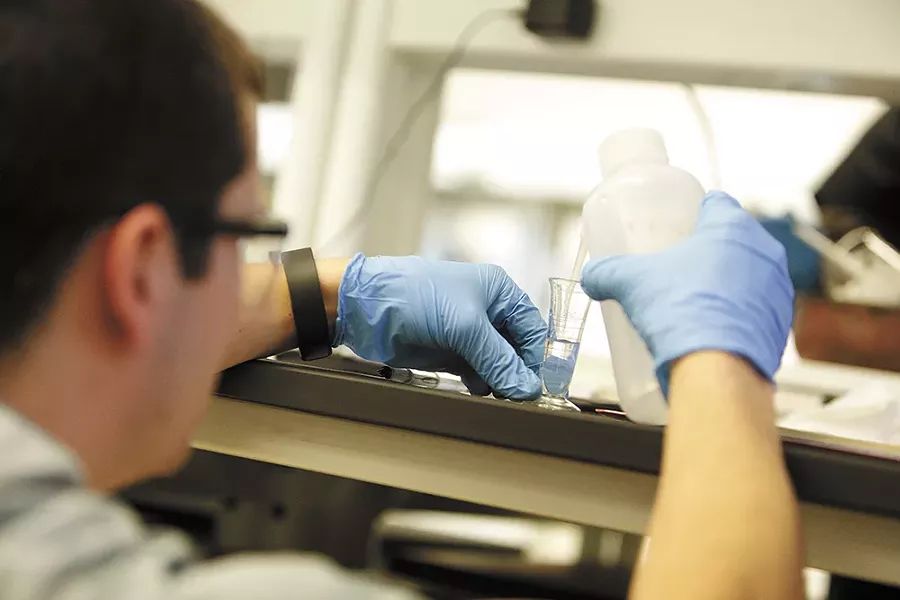 At the compounding lab, students practice custom-crafting medications. First-year student Cody Ray measures deionized water as part of a lab on creating lozenges. - YOUNG KWAK