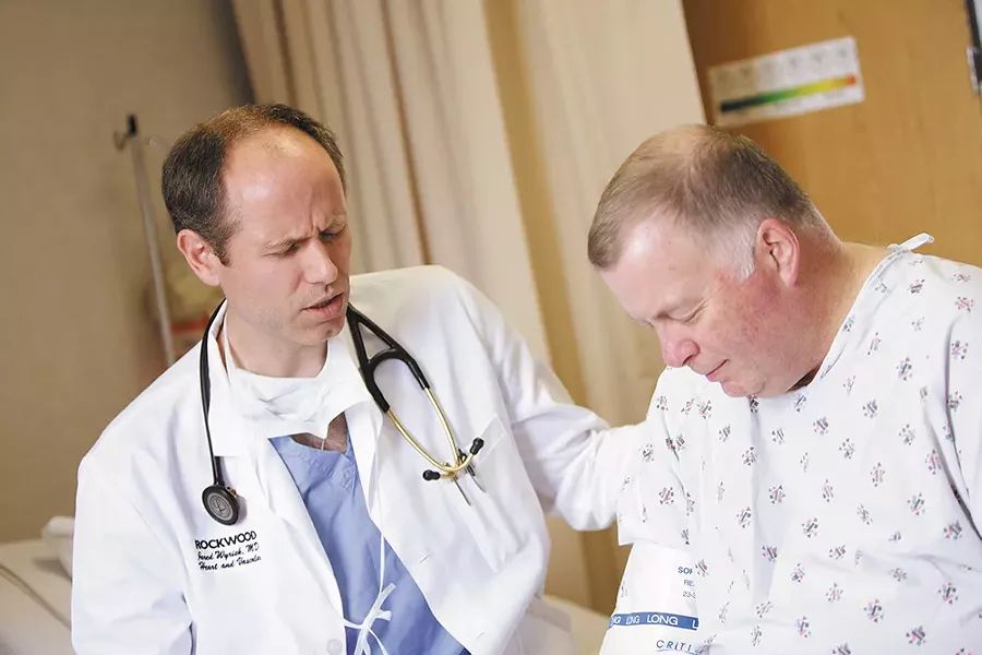 Before a procedure, Dr. Jared Wyrick prays with his patient Greg Boyle at Deaconess Medical Center. - YOUNG KWAK